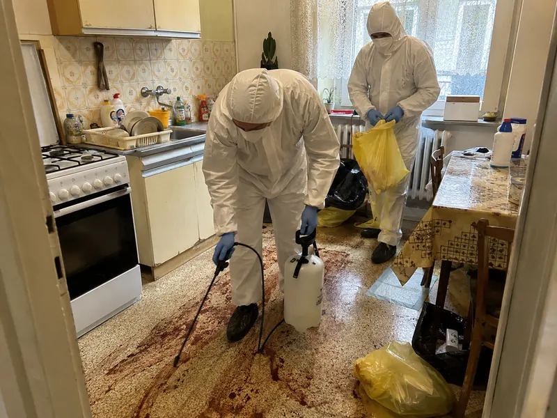 Dezynfekcja podłogi kuchennej po zgonie w mieszkaniu w Bytomiu — pracownicy Bestclean24 w pełnych kombinezonach ochronnych Tyvek aplikują środek biobójczy
